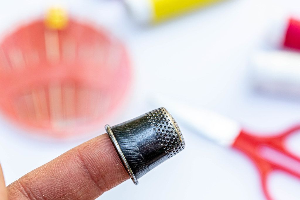 Thimble on finger close-up Thimble on finger close-up