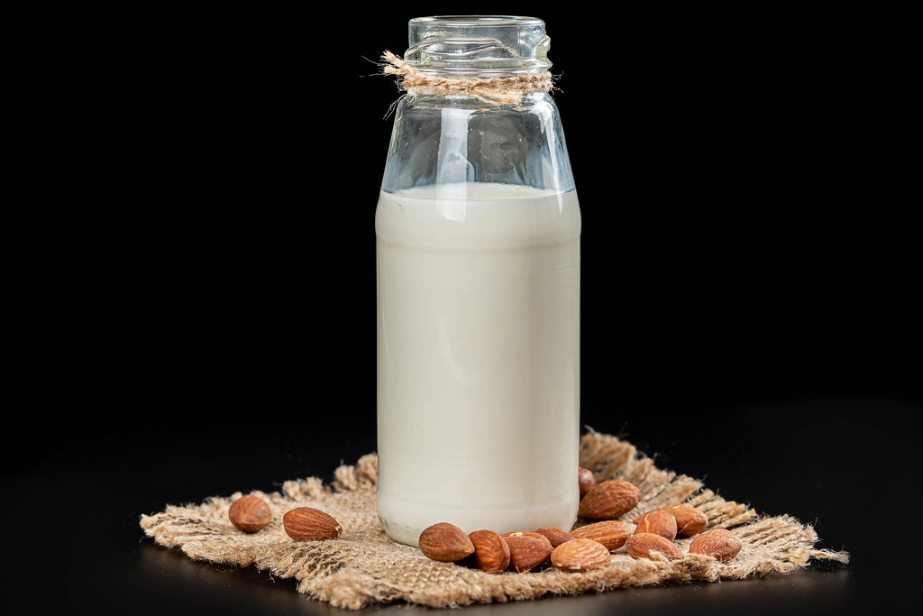 Alternative healthy food concept, almond milk with nuts on a dark background Alternative healthy food concept, almond milk with nuts on a dark background