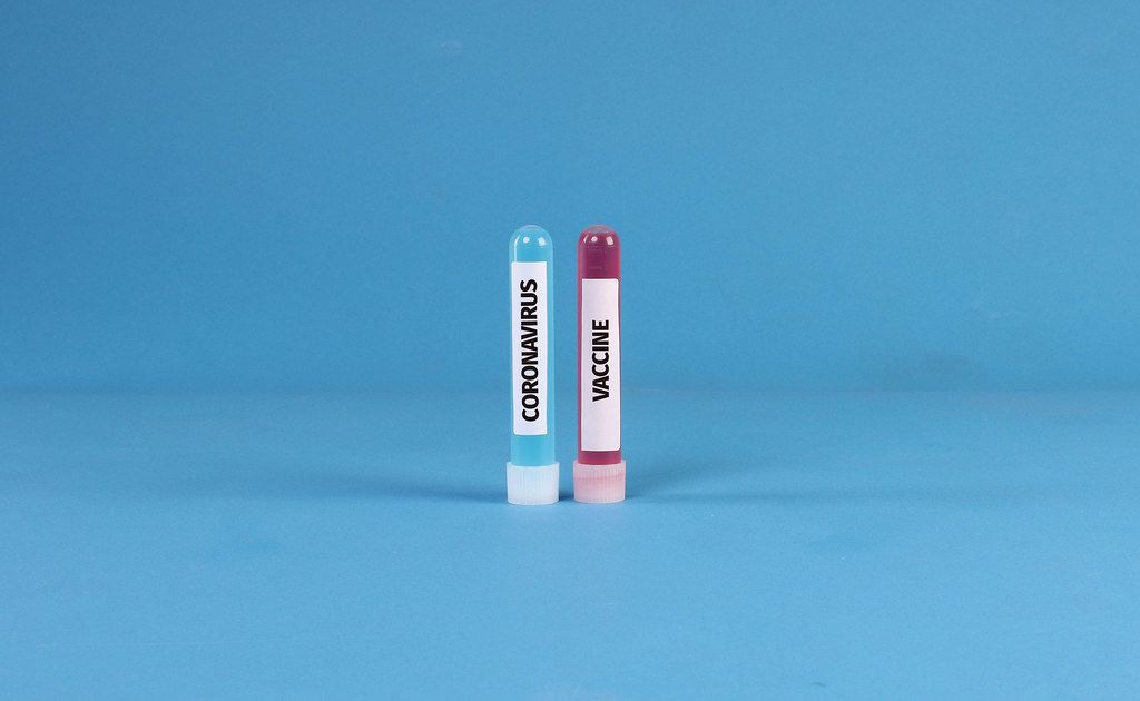 Blue and red test tubes with Coronavirus Vaccine text Blue and red test tubes with Coronavirus Vaccine text