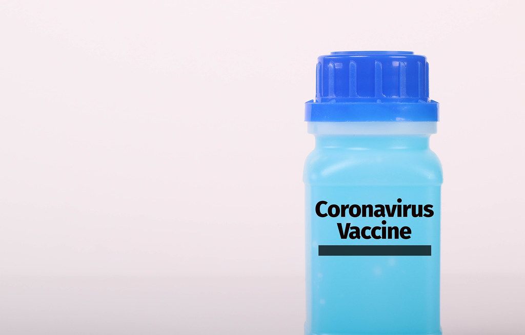Bottle with blue fluid and Coronavirus Vaccine text Bottle with blue fluid and Coronavirus Vaccine text