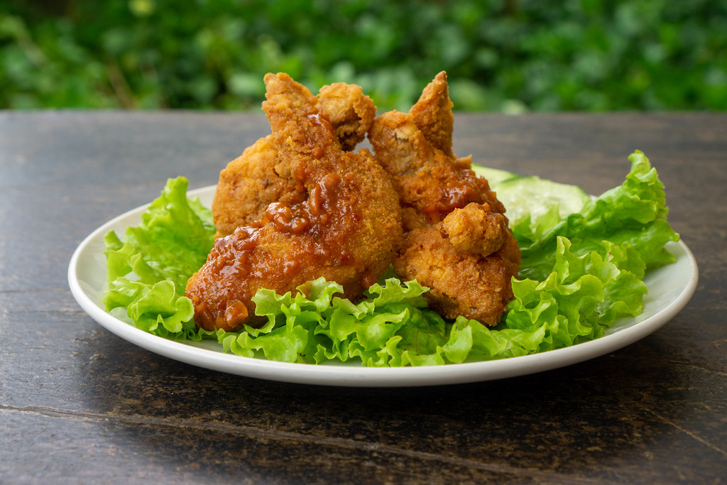 Close Up Food Photo of Fried Chicken Wings with Spicy Tomato Sauce and Lettuce on a White Ceramic Plate Close Up Food Photo of Fried Chicken Wings with Spicy Tomato Sauce and Lettuce on a White Ceramic Plate
