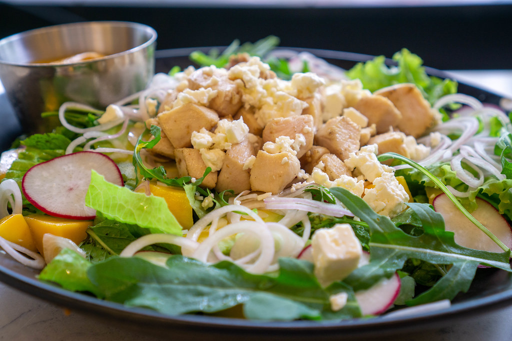 Close Up Food Photo of Mango Curry Chicken Salad with Grilled Chicken Breast, Feta Cheese, Arugula and Onions on a Ceramic Plate Close Up Food Photo of Mango Curry Chicken Salad with Grilled Chicken Breast, Feta Cheese, Arugula and Onions on a Ceramic Plate