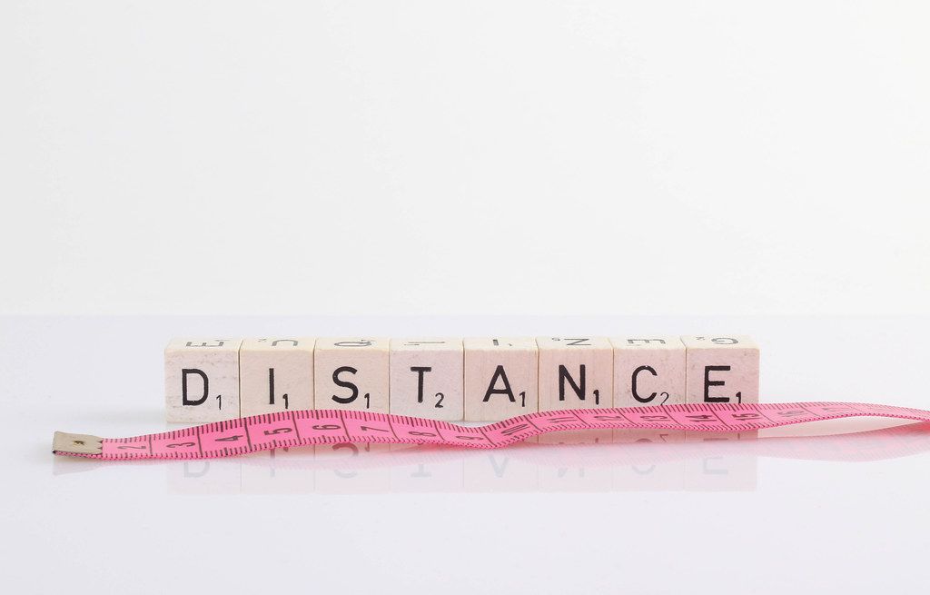 Distance text on wooden blocks with pink tape measure on white background Distance text on wooden blocks with pink tape measure on white background