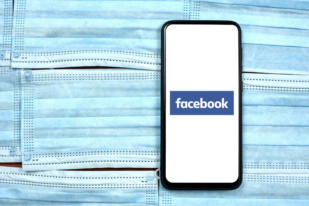 Facebook app on smartphone display. Global company during coronavirus crisis Facebook app on smartphone display. Global company during coronavirus crisis