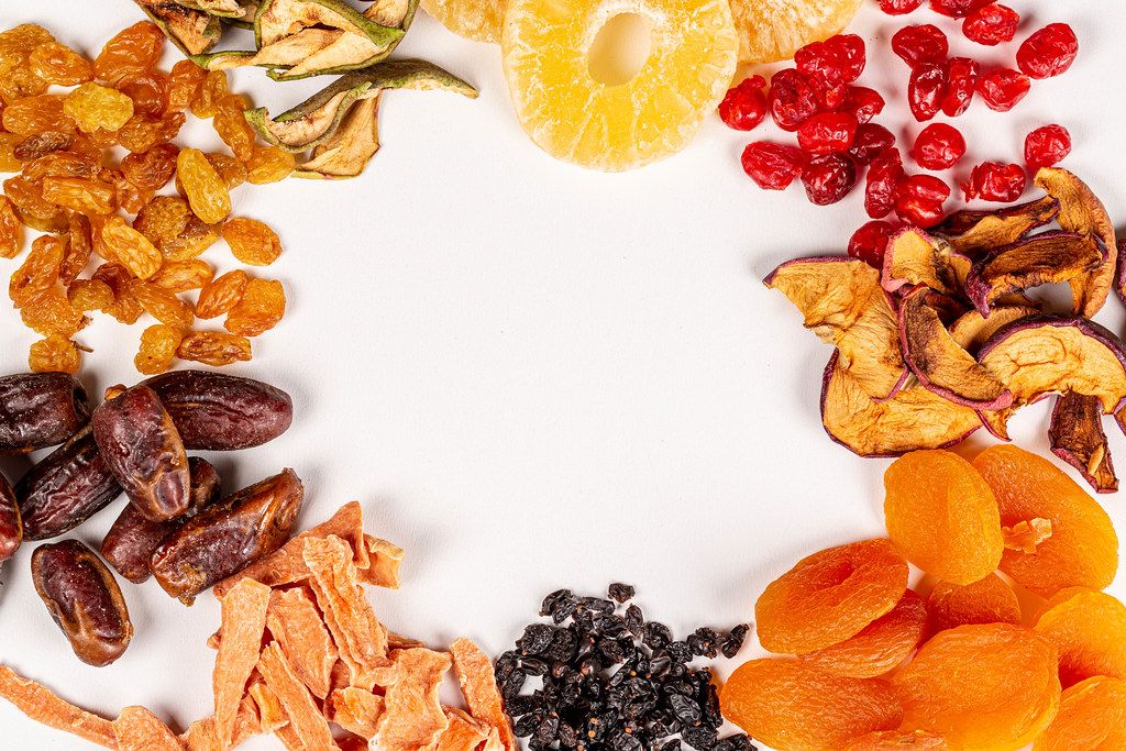 Frame of different dried fruits on white with free space Frame of different dried fruits on white with free space