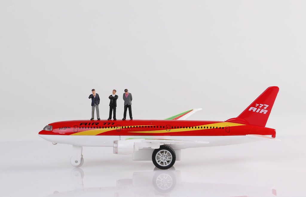 Group of businessman standing on toy airplane Group of businessman standing on toy airplane