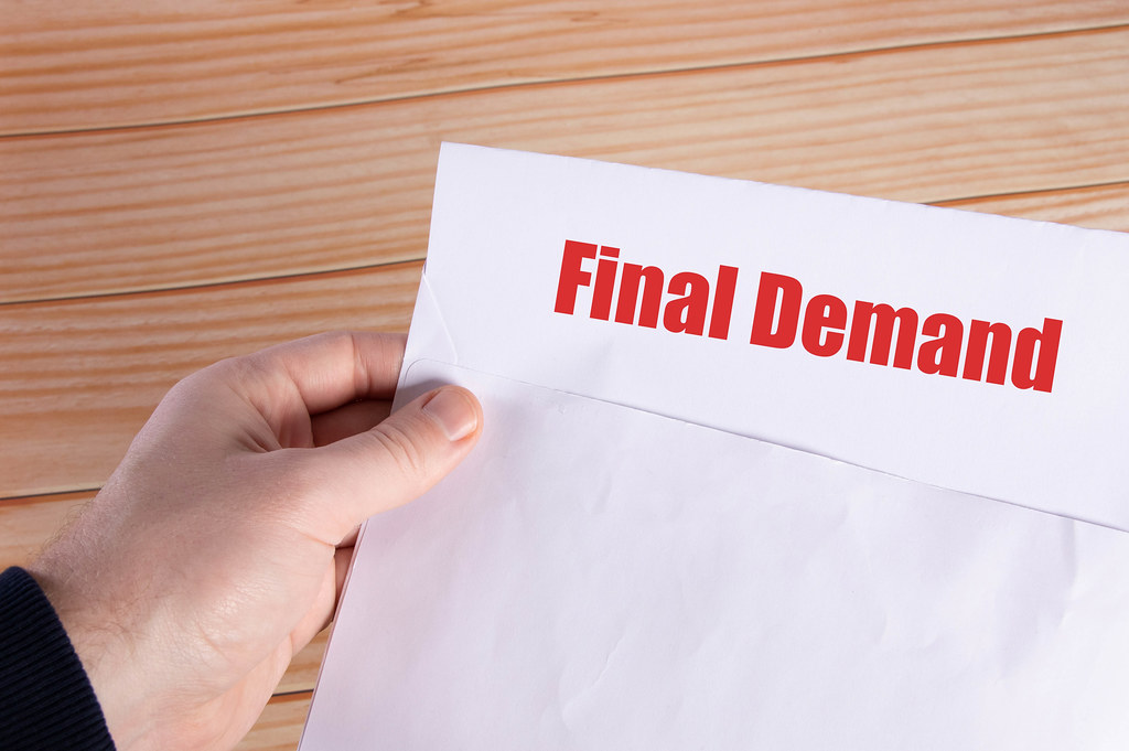 Hand holding open envelope with Final Demand text Hand holding open envelope with Final Demand text