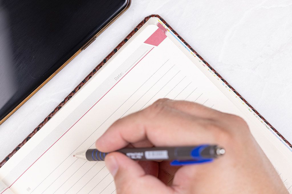Hand with Pencil above Paper Notebook with Business concept Hand with Pencil above Paper Notebook with Business concept