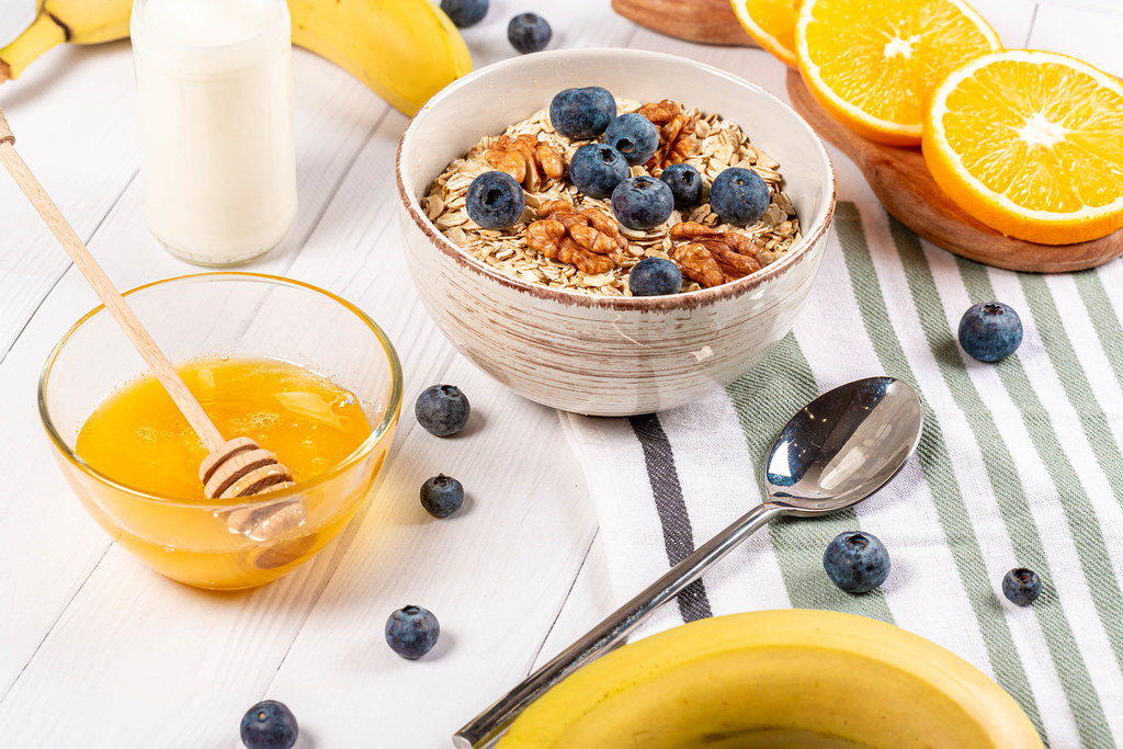 Healthy breakfast background on wooden table with oatmeal, fruit and honey Healthy breakfast background on wooden table with oatmeal, fruit and honey