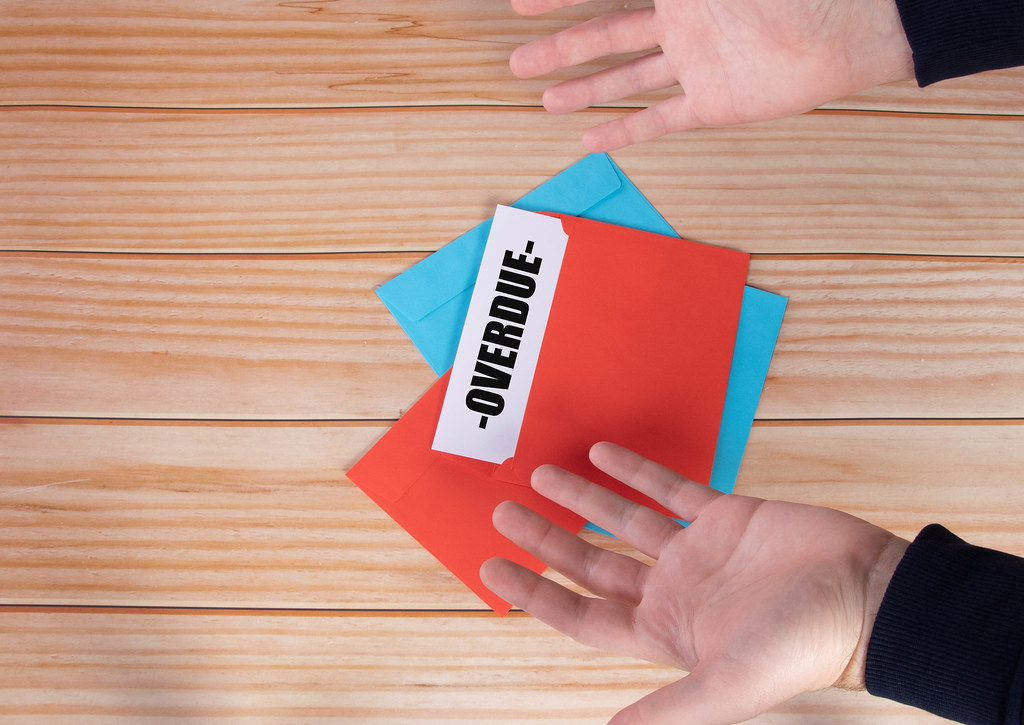 Man opens red envelope with Overdue text Man opens red envelope with Overdue text