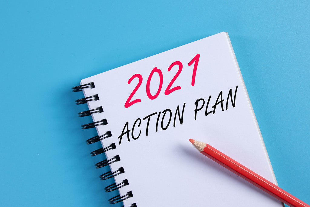 Notebook with 2021 Action Plan text on blue background Notebook with 2021 Action Plan text on blue background