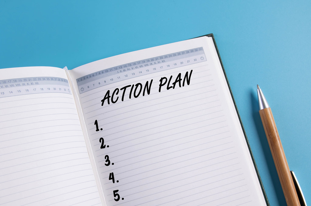 Open notebook with Action plan list on blue background Open notebook with Action plan list on blue background