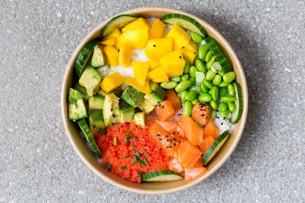 Poké Bowl Lachs: Reisschale mit Mango, Masago, Sojabohnen, Gemüse. Aufnahme von oben Poké Bowl Lachs: Reisschale mit Mango, Masago, Sojabohnen, Gemüse. Aufnahme von oben