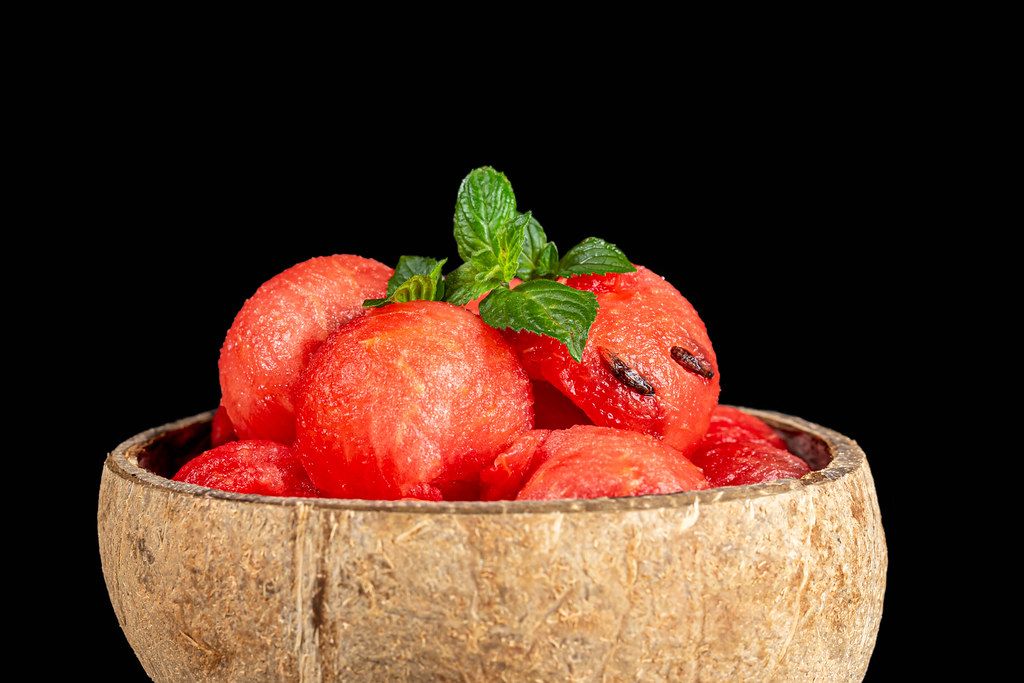 Slices of ripe juicy watermelon with fresh mint on a black background Slices of ripe juicy watermelon with fresh mint on a black background