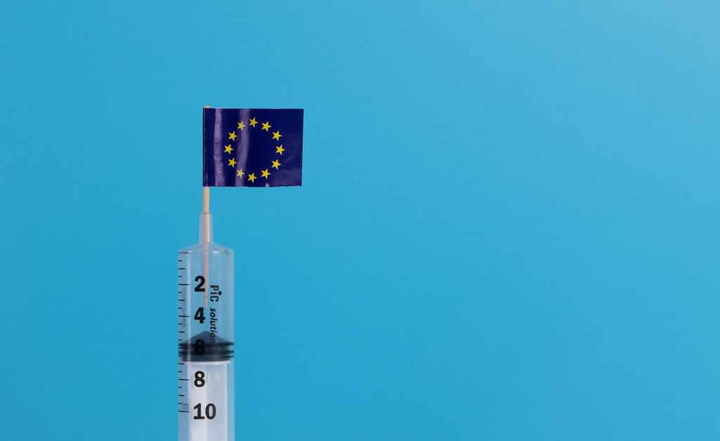 Syringe with flag of EU on blue background Syringe with flag of EU on blue background