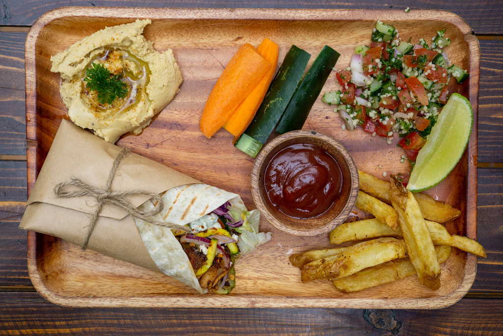 Top View Food Photo of Lunch Plate with Doner Durum Kebab Roll, Homemade Hummus Dip, Fresh Vegetables, Quinoa Salad and French Fries on a Wooden Board with Ketchup and Lime Top View Food Photo of Lunch Plate with Doner Durum Kebab Roll, Homemade Hummus Dip, Fresh Vegetables, Quinoa Salad and French Fries on a Wooden Board with Ketchup and Lime