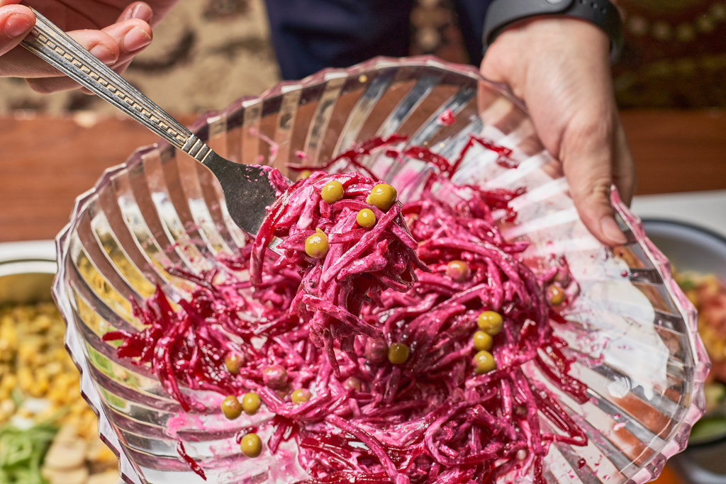 Woman holds a plate of healthy beet salad Woman holds a plate of healthy beet salad