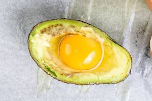Avocado with raw Eggs ready for baking Avocado with raw Eggs ready for baking