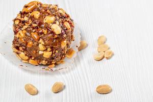 Cake with cocoa and roasted peanuts on a white wooden background Cake with cocoa and roasted peanuts on a white wooden background