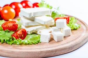 Close Up Food Photo of Stack and Cubes of Feta Cheese, Cherry Tomatoes and Lettuce on Wooden Cutting Board Close Up Food Photo of Stack and Cubes of Feta Cheese, Cherry Tomatoes and Lettuce on Wooden Cutting Board