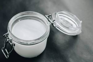 Coconut oil in a jar on dark background Coconut oil in a jar on dark background