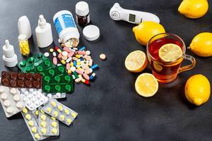Colorful medicines and pills with a Cup of tea and lemons. Concept folk medicine and traditional medicine Colorful medicines and pills with a Cup of tea and lemons. Concept folk medicine and traditional medicine