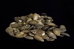 Dried saulty Pumpkin Seeds above black background Dried saulty Pumpkin Seeds above black background