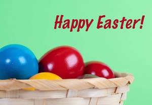 Easter eggs in a basket with Happy Easter text on green background Easter eggs in a basket with Happy Easter text on green background