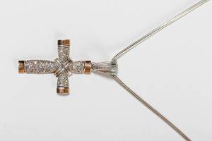 Ein Kreuz aus Silber an einer Kette auf weißem Hintergrund