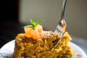 Fork inserted in a piece of carrot cake Fork inserted in a piece of carrot cake