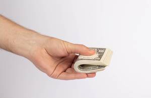 Hand holding stack of dollar bills Hand holding stack of dollar bills