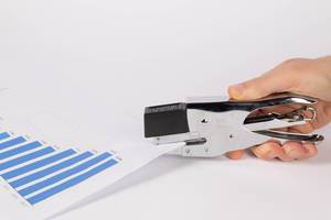 Hand stapling paper on white background Hand stapling paper on white background