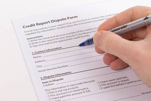 Man filling out Consumer Credit Report Dispute Form Man filling out Consumer Credit Report Dispute Form