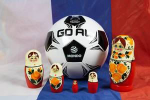 Matryoshka dolls standing around soccer ball on Russian flag Matryoshka dolls standing around soccer ball on Russian flag