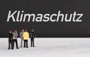 People standing in front of klimaschutz text People standing in front of klimaschutz text