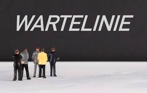 People standing in front of Wartelinie text People standing in front of Wartelinie text
