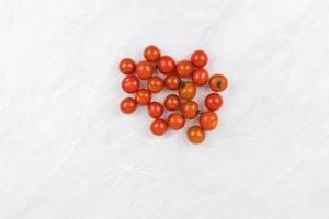 Pile of Cherry Tomatoes on the grey marble table with copy space Pile of Cherry Tomatoes on the grey marble table with copy space