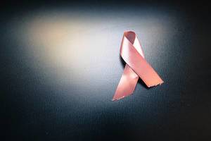 pink cancer awareness ribbon on black background pink cancer awareness ribbon on black background
