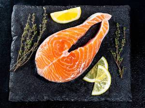 Raw salmon fillets on dark background Raw salmon fillets on dark background