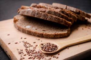 Slices of dark fresh bread with seeds on dark wooden background Slices of dark fresh bread with seeds on dark wooden background