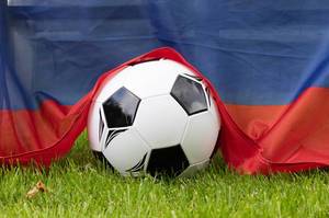 Soccer ball on grass covered with Russian flag Soccer ball on grass covered with Russian flag