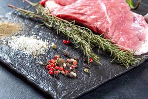 Spices and raw meat steak on black background Spices and raw meat steak on black background