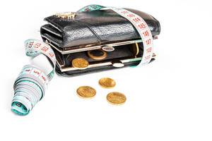 The concept of crisis, lack of money, loss of financial stability - wallet with coins and a measuring tape The concept of crisis, lack of money, loss of financial stability - wallet with coins and a measuring tape