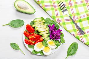 Top view healthy food background. Boiled eggs with fresh vegetables and spinach Top view healthy food background. Boiled eggs with fresh vegetables and spinach
