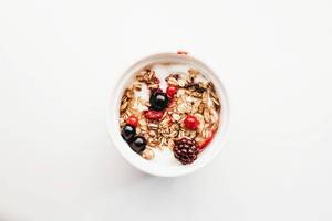 Top view of healthy breakfast- muesli with yogurt and fruits. White background.jpg Top view of healthy breakfast- muesli with yogurt and fruits. White background.jpg