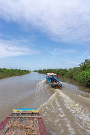 Two Boats driving on a River leading to Tonle Sap Lake in Siem Reap Two Boats driving on a River leading to Tonle Sap Lake in Siem Reap