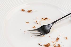 White empty Plate with piece of Cake Leftovers and Fork White empty Plate with piece of Cake Leftovers and Fork