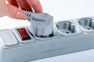 Woman hand plugging in appliance to portable socket