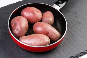Young Potatoes in Frying Pan on the black stone tray Young Potatoes in Frying Pan on the black stone tray